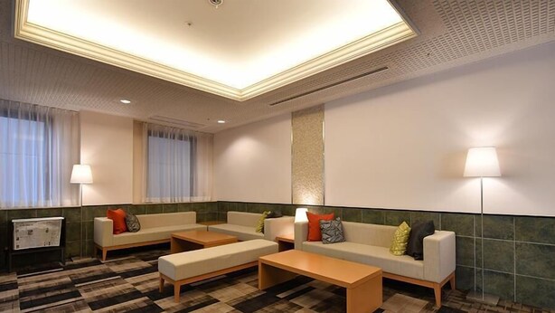 A hotel lobby with a check-in counter, seating area with sofas and a coffee table, and a large window with curtains. - Richmond Hotel Hamamatsu (Hamamatsu)