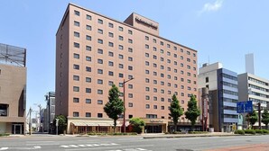 A multi-story hotel with a uniform facade, a visible sign indicating it is a Richmond Hotel, and a clear road in front. - Richmond Hotel Hamamatsu (Hamamatsu)