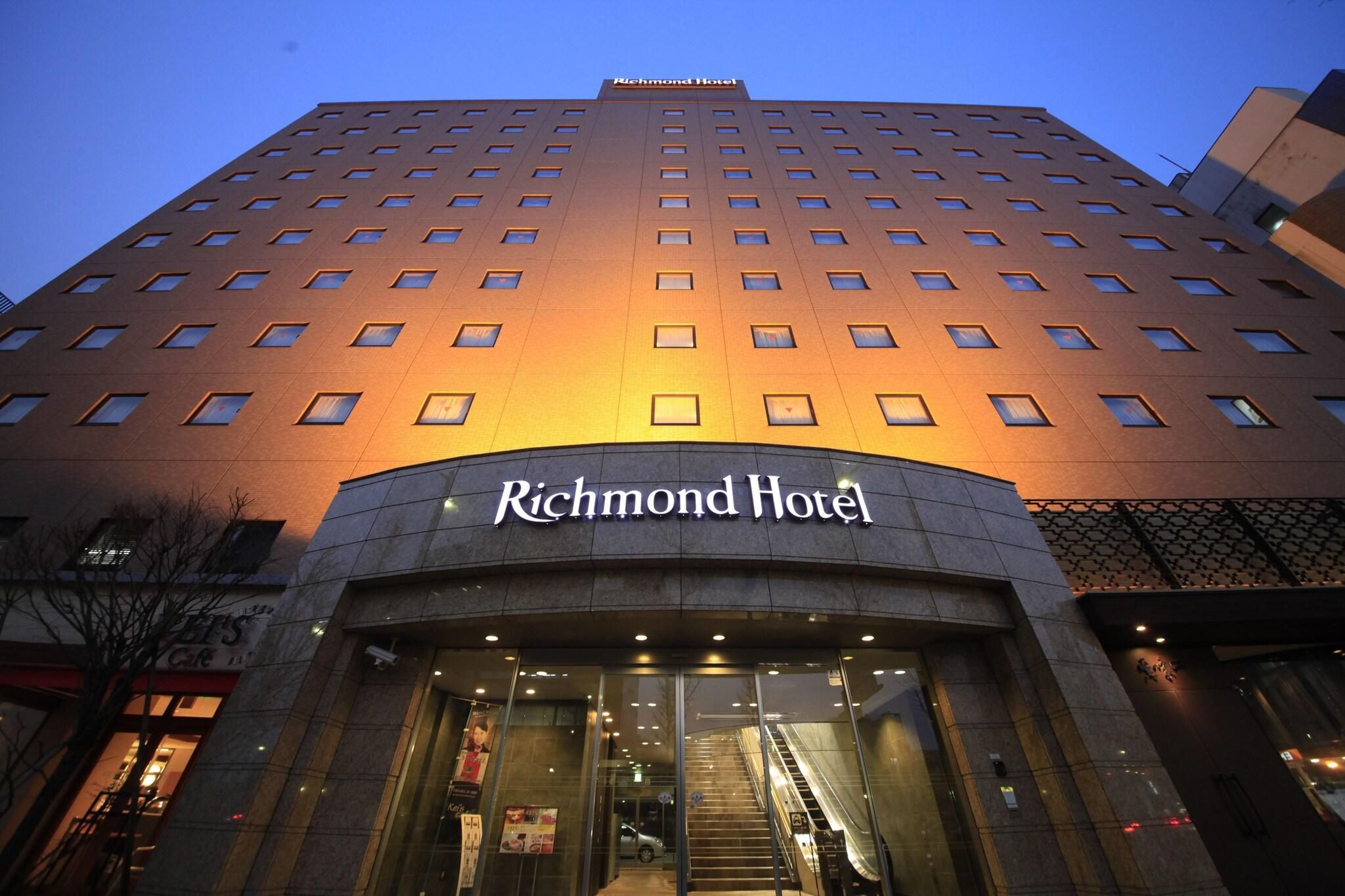 Un grand immeuble surmonté d’une enseigne « Richmond Hotel » et portant une enseigne similaire à l’entrée.