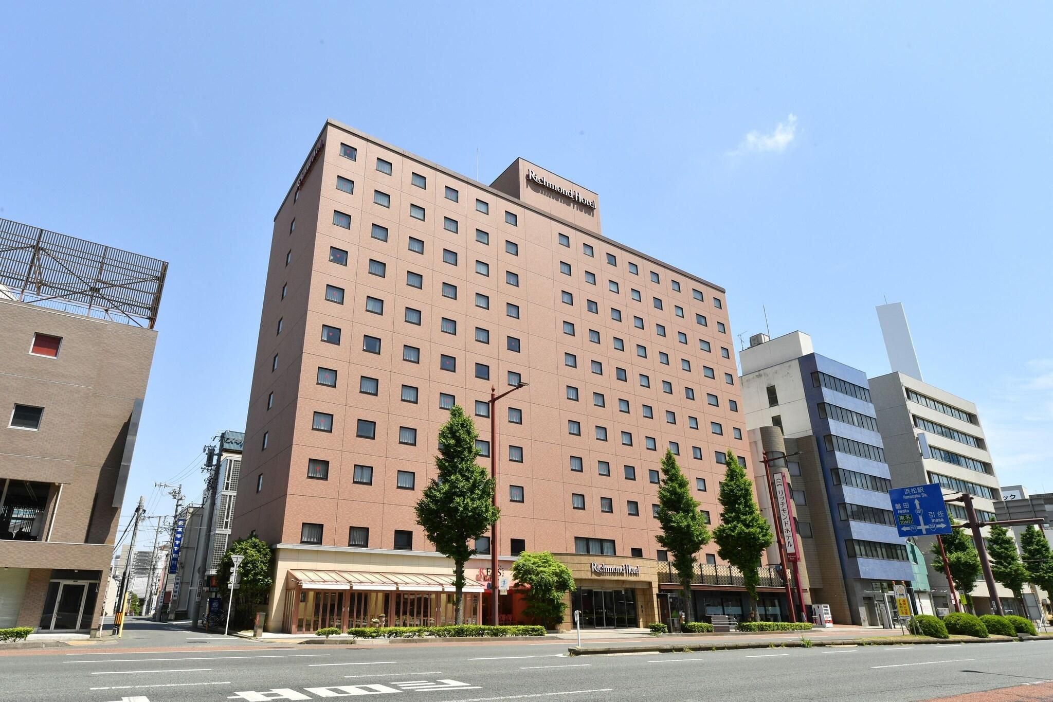 A multi-story hotel with a uniform facade, a rooftop terrace, and a clear sky.