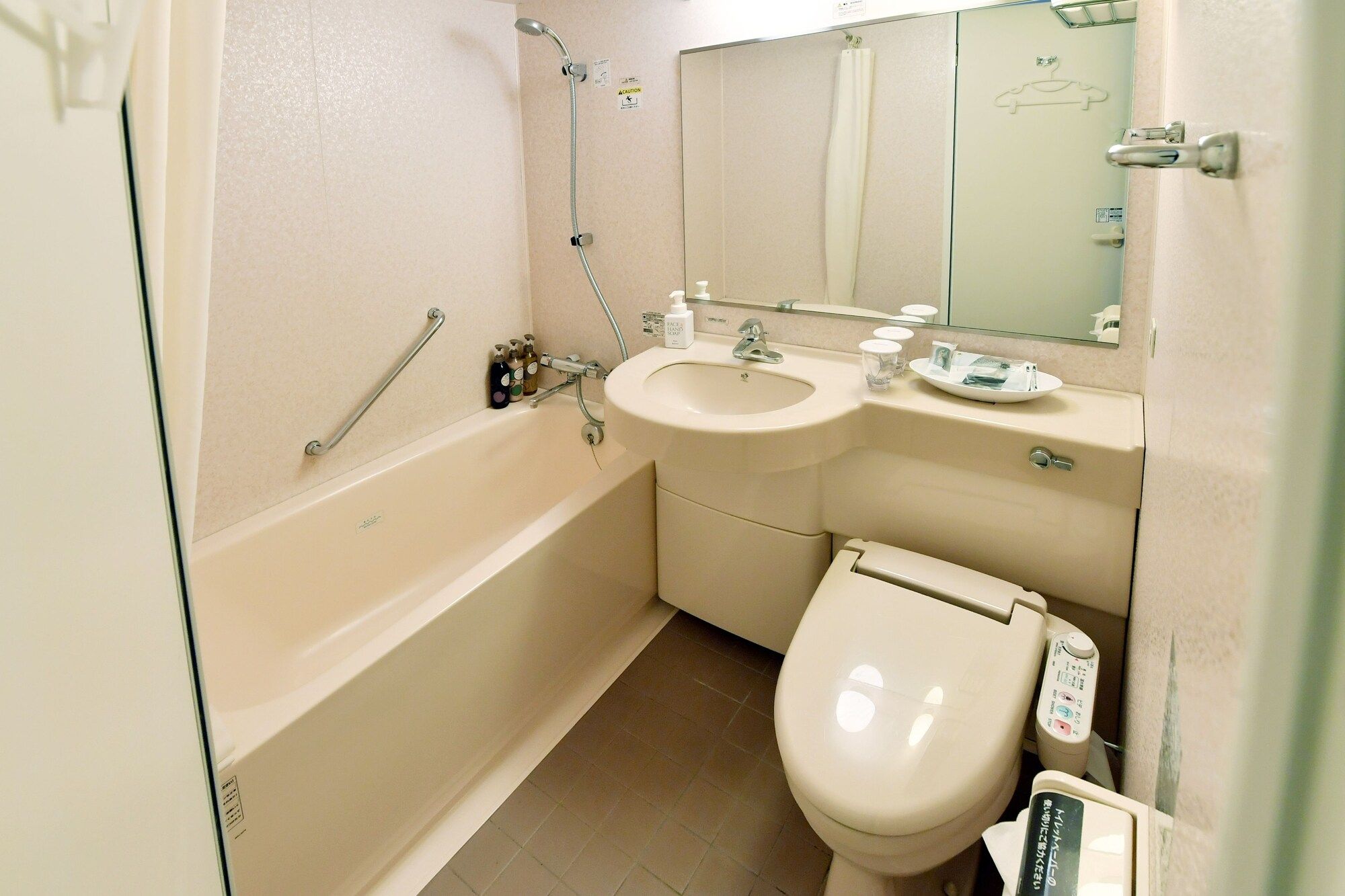 A bathroom with a bathtub, a toilet, a sink, and a mirror.