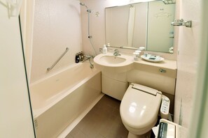 Une salle de bain avec une baignoire, des toilettes, un lavabo et un miroir.