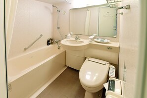 Un baño con bañera, lavamanos, inodoro y espejo.