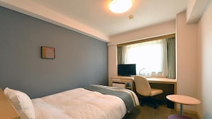 A hotel room with a bed, desk, chair, and a small table. - Richmond Hotel Hamamatsu (Hamamatsu)