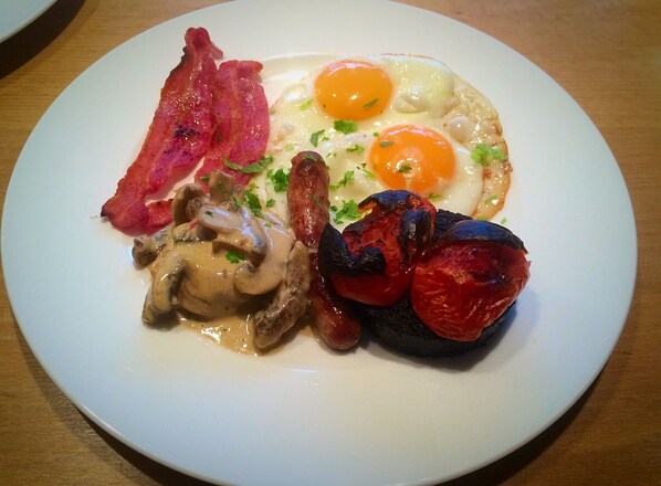 A plate with bacon, fried eggs, mushrooms, and tomatoes. - Melfort House (Oban)