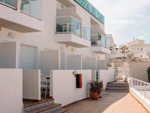 Ein modernes Gebäude mit Balkonen, einem Schild mit der Aufschrift 'Hostal Del Cabo' und einem gefliesten Boden.