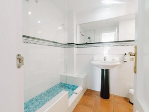 Ein Badezimmer mit Dusche, Waschbecken und Toilette.