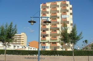 Un edificio de varios pisos con balcones, un farol y un cartel que dice 'EUROPEAN SCHOOL'.