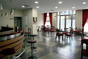 A hotel lobby with a reception desk, multiple dining tables with chairs, and a check-in counter. - Hotel Virgen de Covadonga (Cangas de Onis)