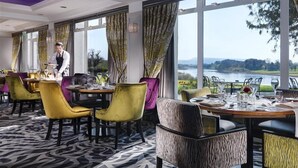 Ein Restaurant mit Seeblick, ein Kellner bedient Gäste.