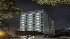Un grand immeuble sur lequel on peut lire, en haut, l’inscription « Hôtel de l’aéroport de Jeju ».