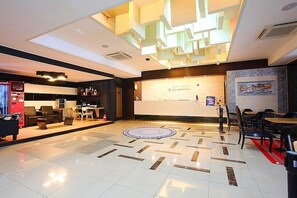 A modern lobby with a reception desk, seating area, and a patterned floor. - Jeju Airport Hotel (Jeju City)