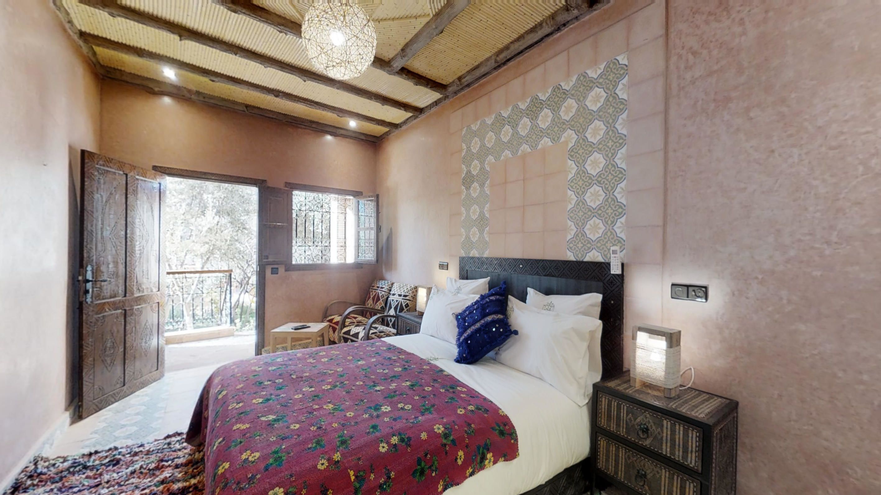 Un dormitorio con cama, mesita de noche y vistas al exterior.