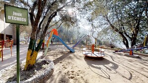 A playground with a slide, swings, and a merry-go-round. - Ferme By Ikalimo (Sti Fadma)