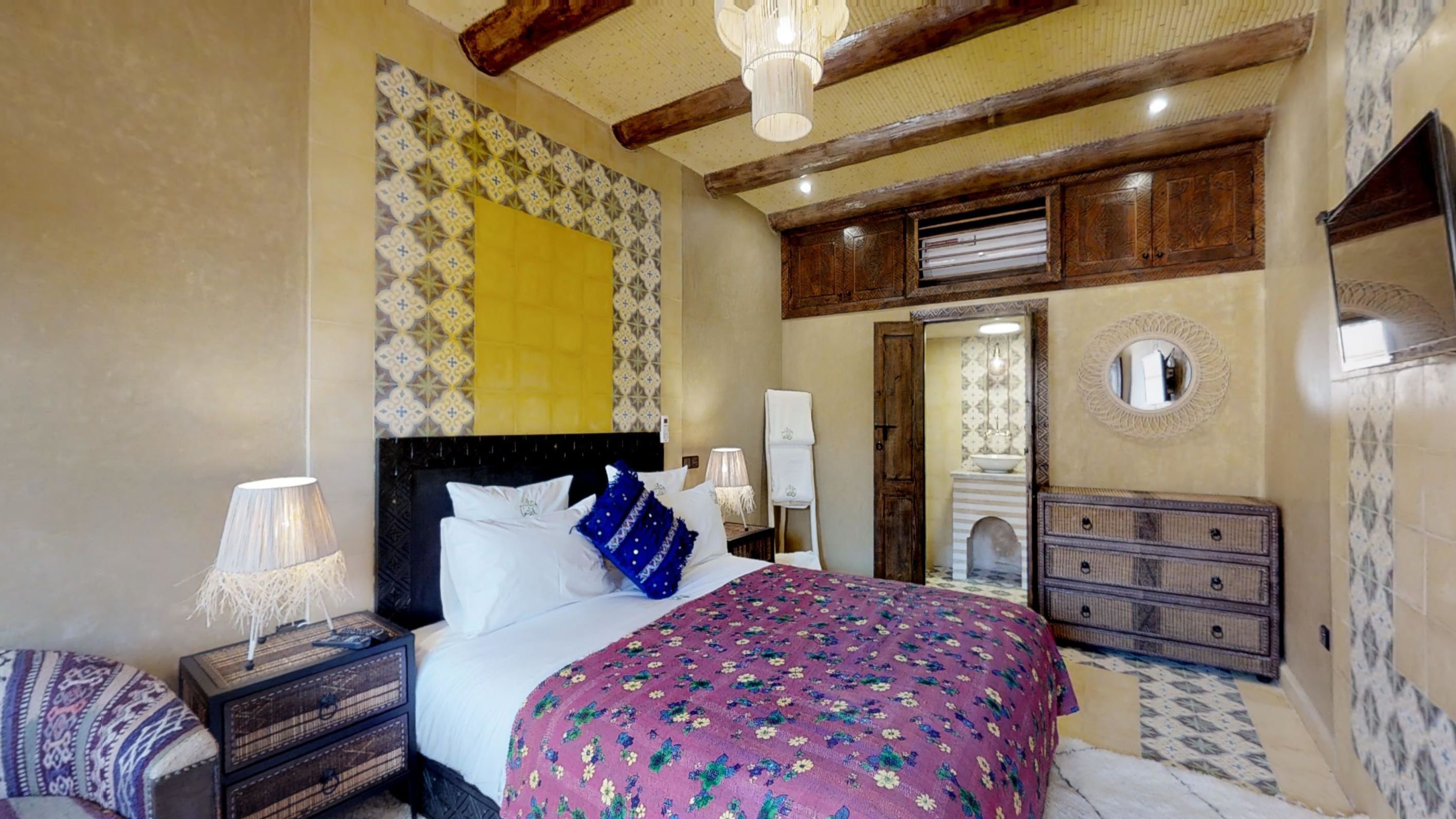 A bedroom with a bed, nightstands, a dresser, and a mirror.