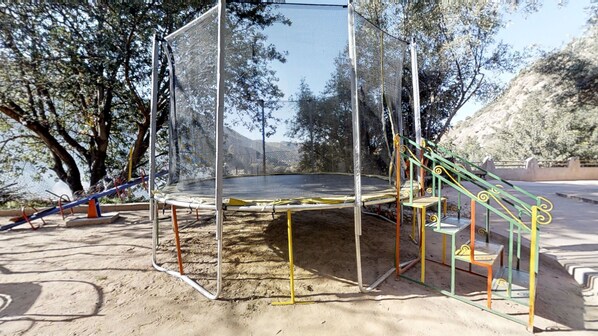 A playground with a trampoline, slides, and a climbing structure. - Ferme By Ikalimo (Sti Fadma)