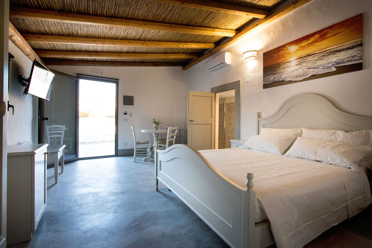 A bedroom with a bed, a desk, and a chair.