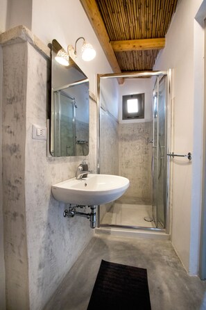 A bathroom with a white sink, a mirror, and a glass shower enclosure. - Le Finestre Su Porta Carrese - Luxury Rooms  (Matino)