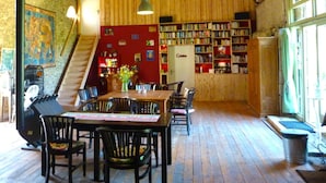 Une bibliothèque chaleureuse avec un plancher en bois, un escalier et des étagères remplies de livres.