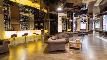 A bar area with stools, a sofa, and a coffee table.