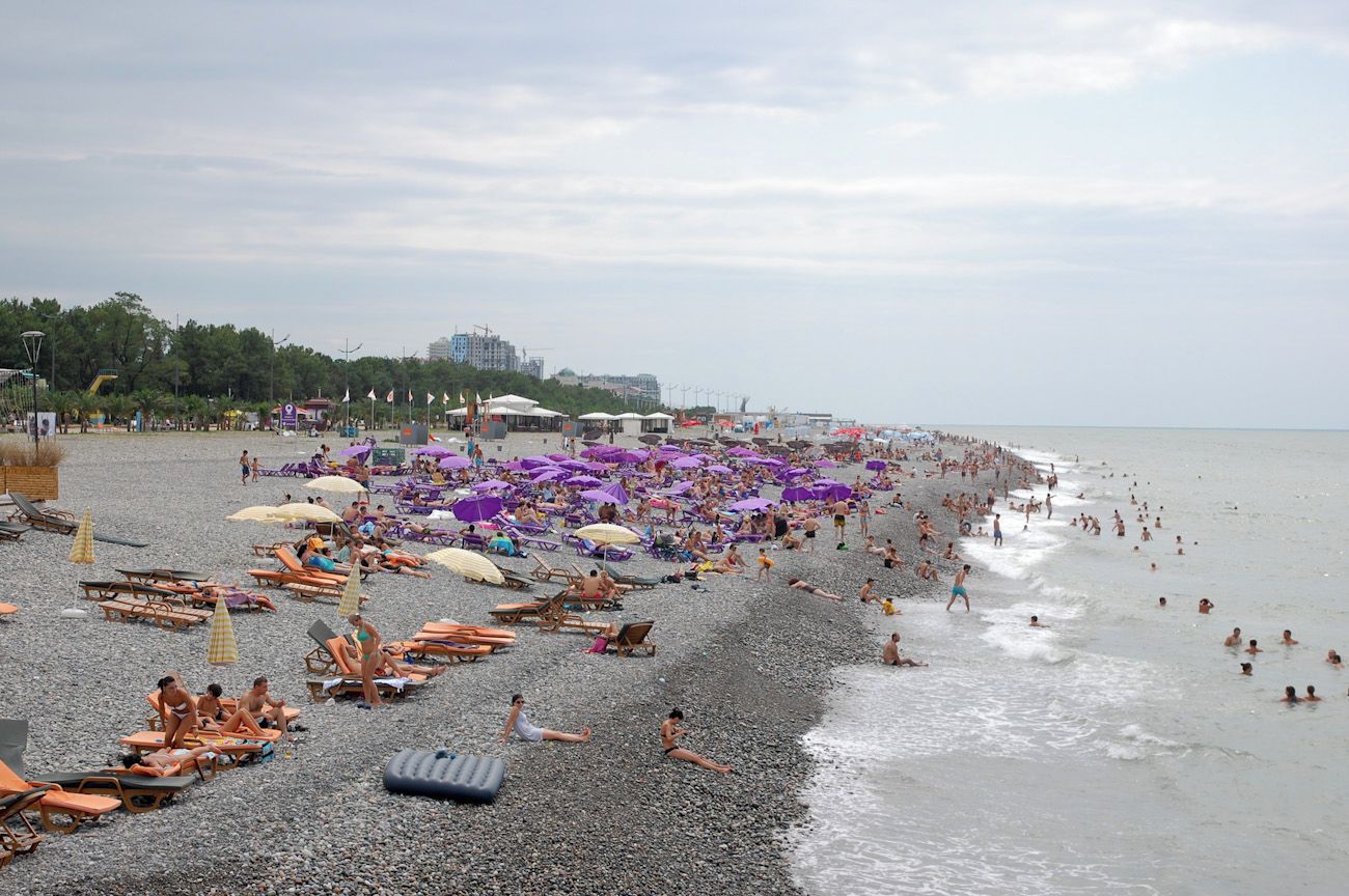 A beach with numerous sun loungers and umbrellas.