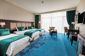 A hotel room with two beds, a desk, a chair, and a TV. - JRW Welmond Hotel (Batumi)