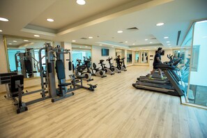 A gym with treadmills, stationary bikes, and weight machines. - JRW Welmond Hotel (Batumi)