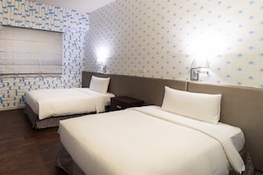 A hotel room with two beds, a patterned wall, and a nightstand with a lamp. - Joy Hotel Sanchong (New Taipei City)