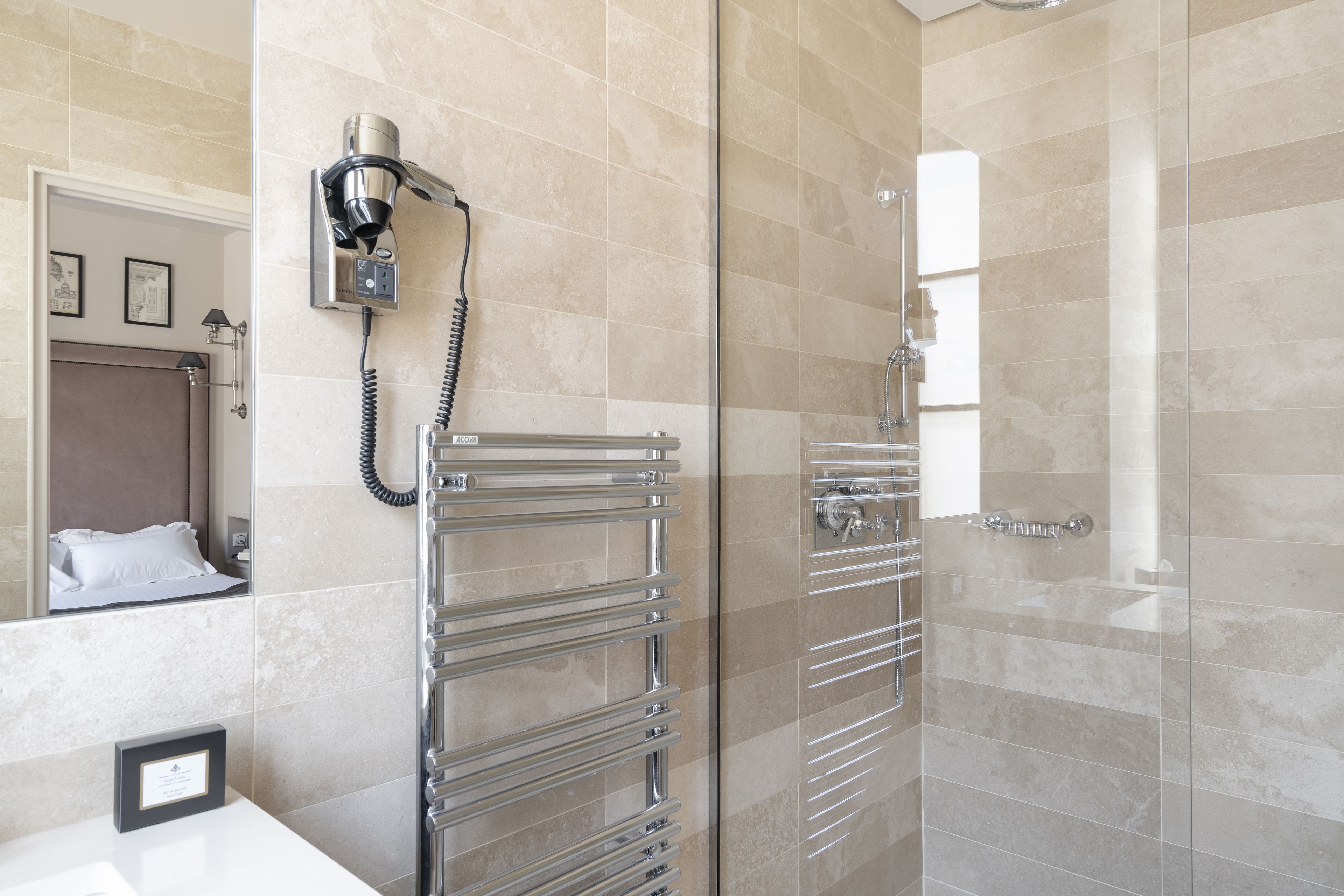 Un baño moderno con cabina de ducha de vidrio, toallero empotrado y espejo con marco.