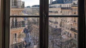 A window with a view of a cityscape, including buildings and a tower. - Hotel Le Presbytère (Paris)