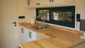 A compact kitchen with white cabinetry, a wooden countertop, and a built-in microwave. - Yol Glamping Hotel Retreat Center (Fethiye)