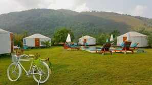 Un camping con yurtas, piscina y bicicleta.