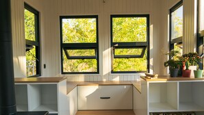 A compact kitchen with built-in appliances, a stove, and a window overlooking greenery. - Yol Glamping Hotel Retreat Center (Fethiye)