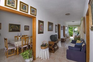 Un salón espacioso con comedor, televisor y sofá.