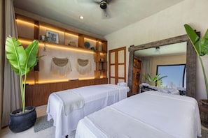 A room with two beds, a wooden wall with shelves, a mirror, and large green plants. - Hotel Era Tulum (Tulum)