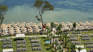 A beach resort with sun loungers, umbrellas, and a pool. - Liberty Kusadasi (Kuşadası)