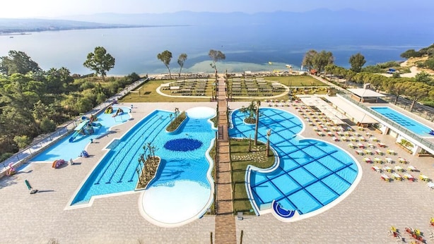 A resort with multiple swimming pools, a central pathway, and a view of the sea. - Liberty Kusadasi (Kuşadası)