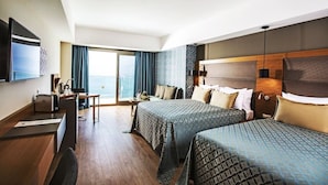 A hotel room with two beds, a desk, a TV, and a balcony with a view. - Liberty Kusadasi (Kuşadası)