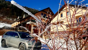 A hotel with a balcony and a car parked in front. - Apartmány Mlynky (Mlynky)