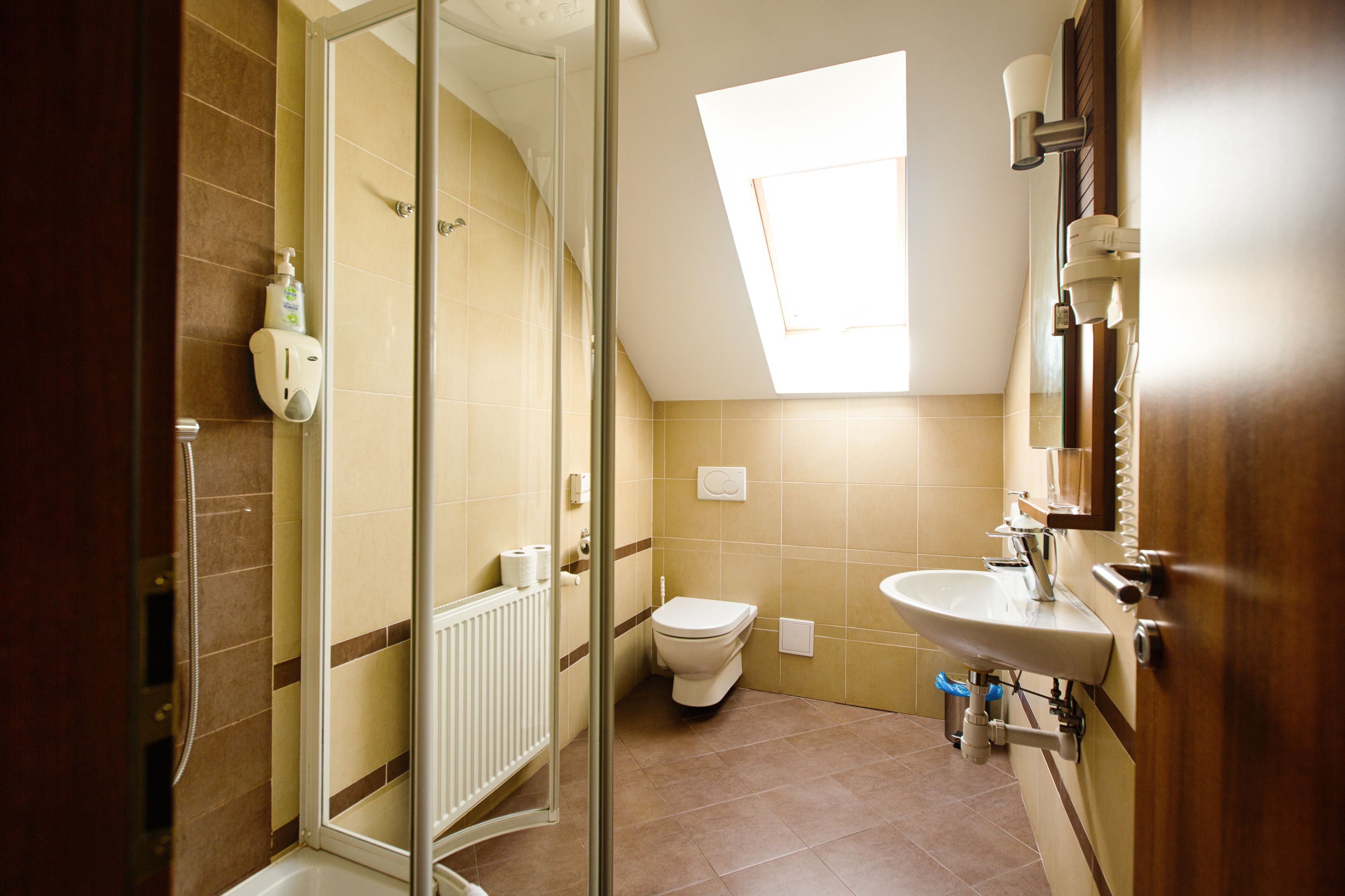 A bathroom with a shower, toilet, and sink.