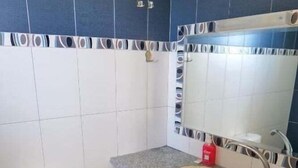 Une salle de bain avec des toilettes, un lavabo et un miroir.