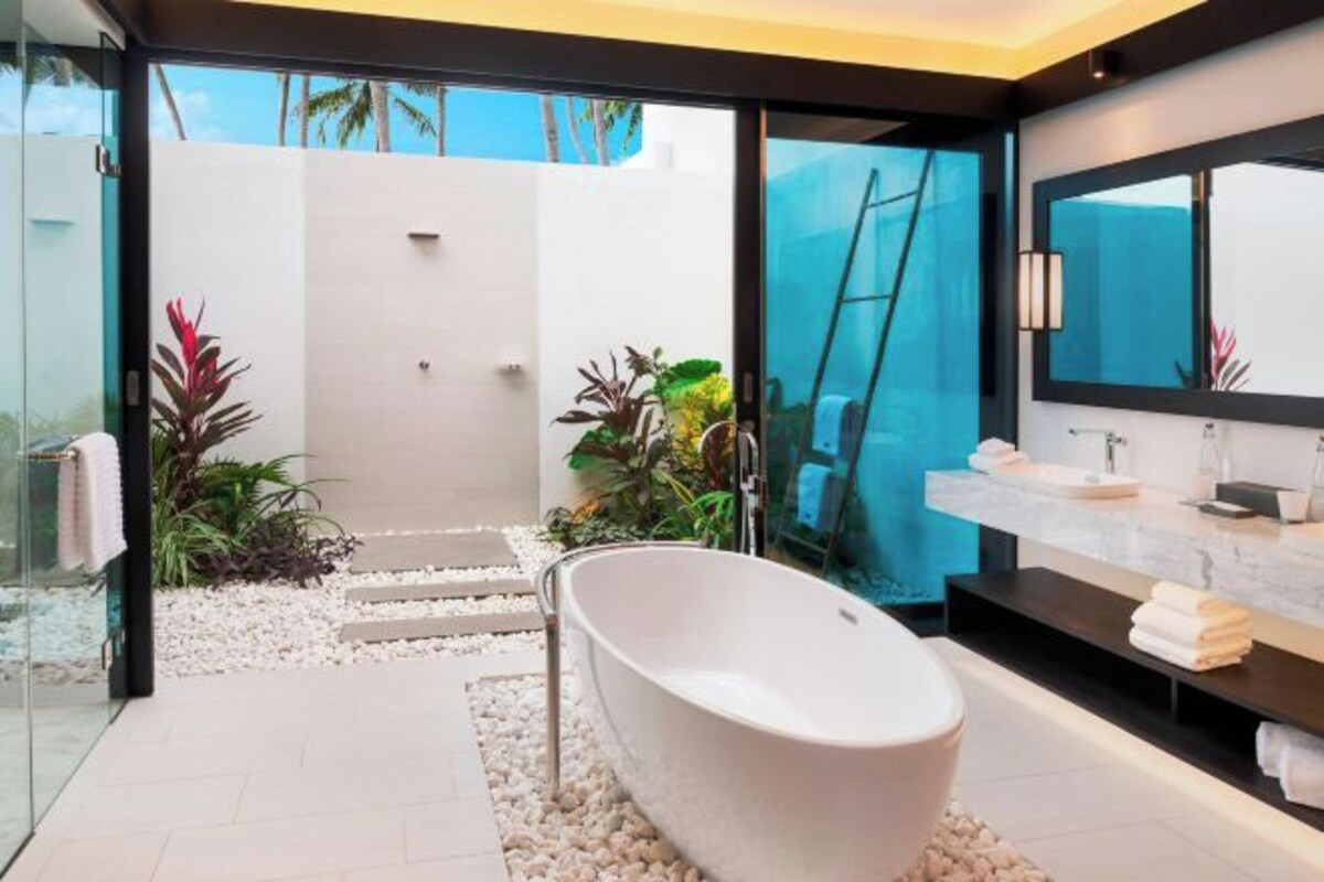 A modern bathroom with a freestanding bathtub, a large mirror, and a vanity with a sink.