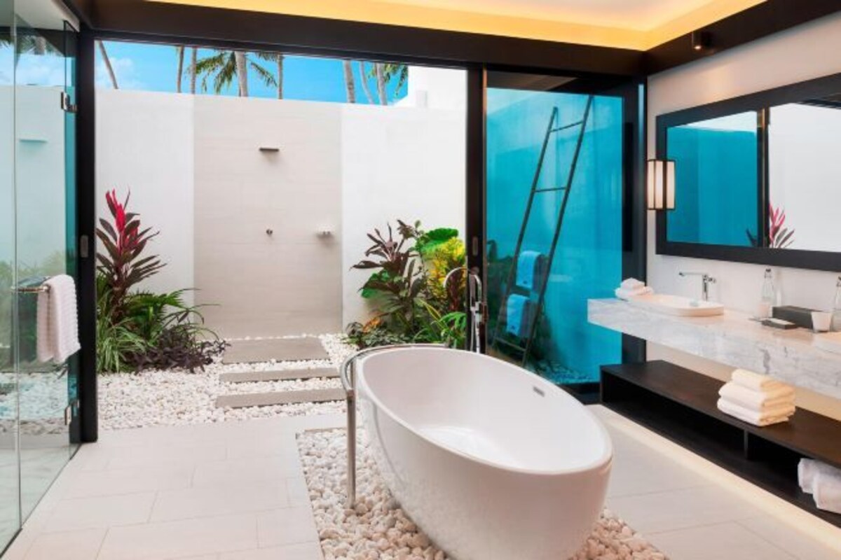 A modern bathroom with a freestanding bathtub, a large mirror, and a glass shower enclosure.