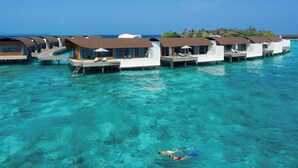 Overwater bungalows with clear blue water, wooden walkways, and a person swimming. - The Westin Maldives Miriandhoo Resort (Miriandhoo Island)