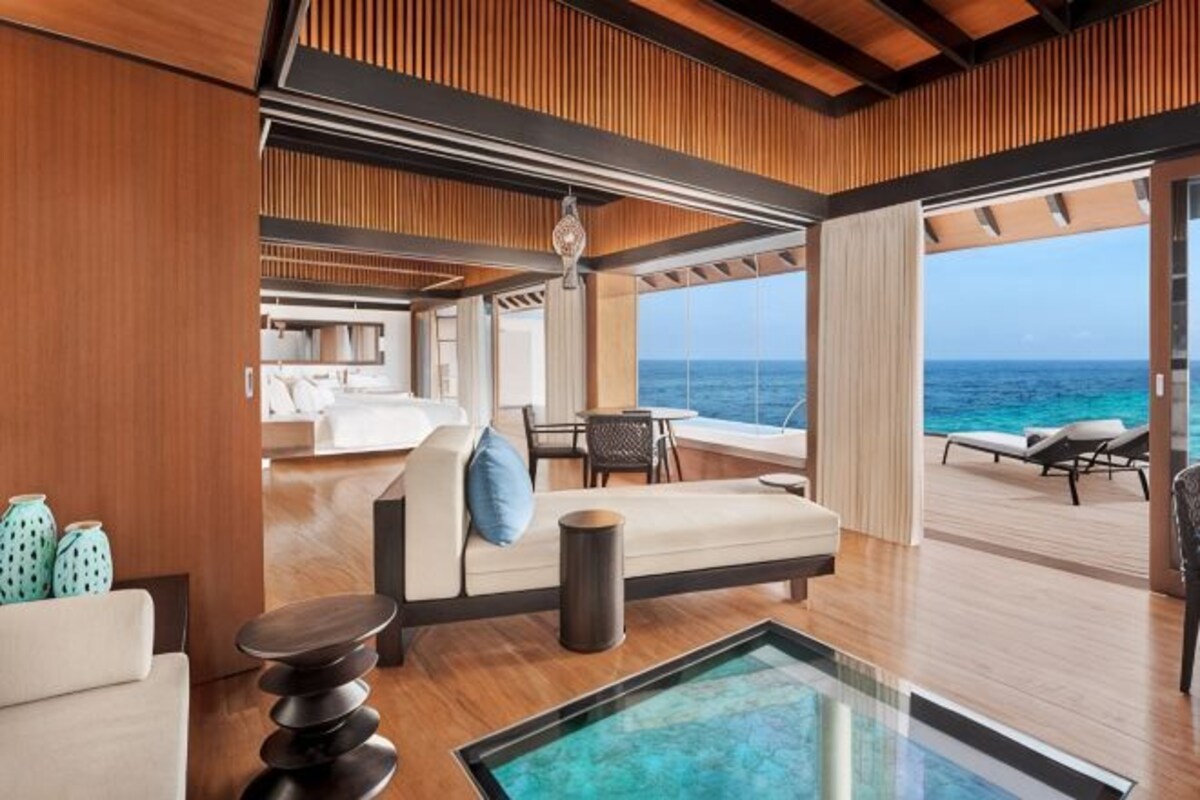A modern interior with a sofa, a coffee table, and a view of the ocean.