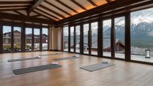 Ein geräumiges Zimmer mit Holzböden und großen Fenstern mit Blick auf die Berge.