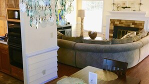 A living room with a wooden table, a sofa, and a chandelier.