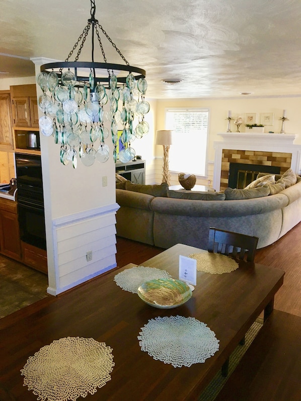 Un salon avec une table en bois, un canapé et un lustre.