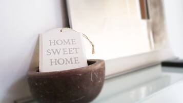Eine dunkelbraune Keramikschale mit einem Schild, auf dem der Text 'HOME SWEET HOME' vor weißem Hintergrund steht.