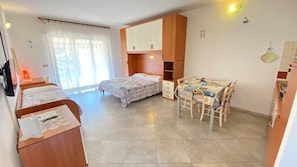 A bedroom with two beds, a desk, and a wardrobe. - Residence le Rose (Bibbona)